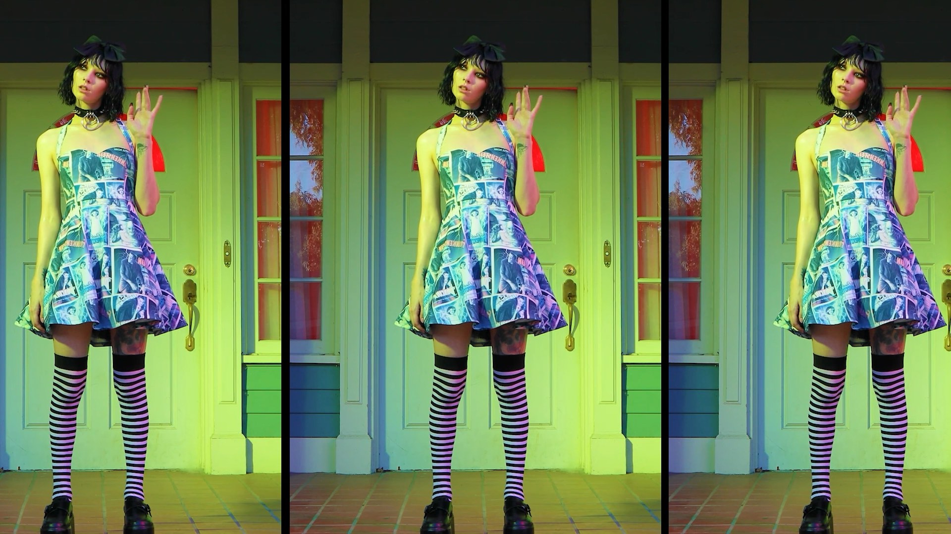 Person in a colorful dress and striped socks poses playfully in front of a green door.